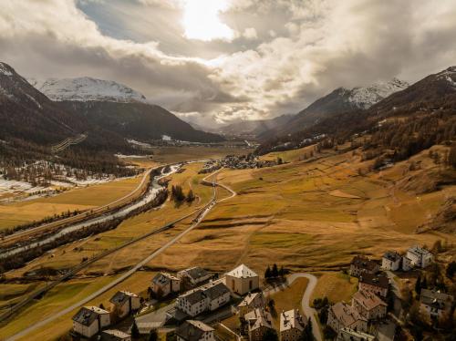 an aerial view of a village in a valley with mountains at La Senda Smart Hotel Zuoz in Zuoz
