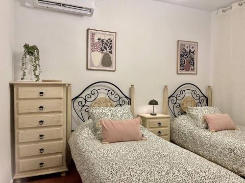 una camera da letto con due letti e un comò di Apartamento Laurencia a Fuente Obejuna