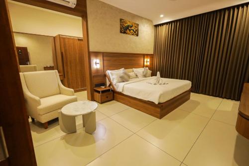a hotel room with a bed and a chair at Town Square Residency in Kommeri