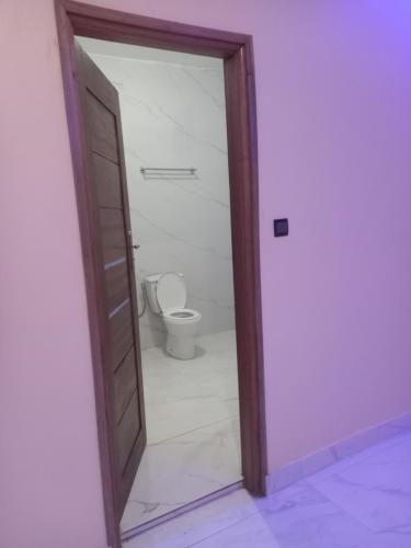 an open door to a bathroom with a toilet at Femi in Dakar
