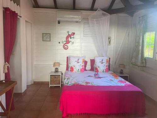 Rivière-SaléeVilla Manguier的卧室里有一张床，上面铺着粉色毯子