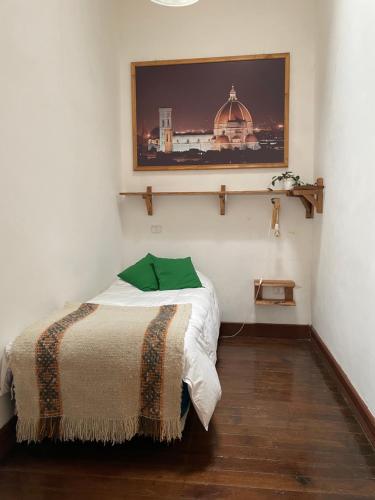a bedroom with a bed with a picture on the wall at Hostal Ekeka House in Valparaíso