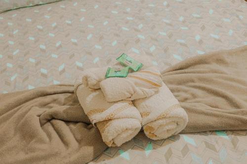 a stuffed animal in a towel on a bed at Hospedaria Oliveira - Santo Amaro do Maranhão in Queimada