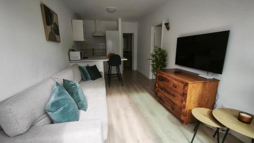ein Wohnzimmer mit Sofa und Flachbildfernseher in der Unterkunft Take it easy in Corralejo in Corralejo