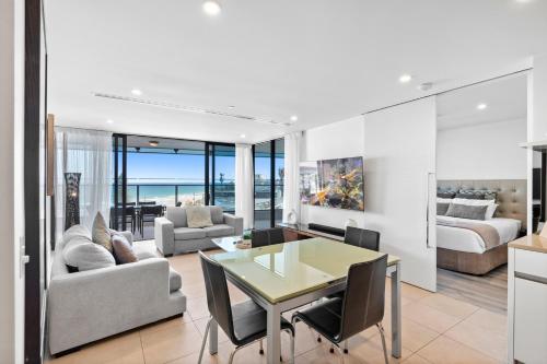 a living room with a table and a dining room at Soul Beachfront Apartments - HR Surfers Paradise in Gold Coast