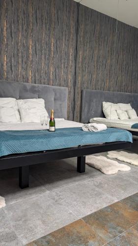 a bed with a bottle of wine on top of it at Szampan i Truskawka in Toruń