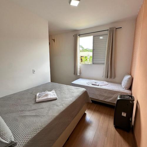 two beds in a small room with a window at Grace Prime Loft – Comfort in Extrema, MG in Extrema