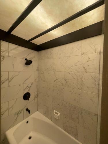 ein Badezimmer mit weißer Badewanne und Marmorwänden in der Unterkunft Hotel-Style Private Suite-Lake View-Gardens in Lake Wales