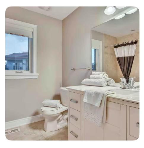 a bathroom with a sink and a toilet and a mirror at Riverside Dreams in Wasaga Beach