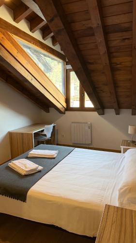 a bedroom with a large white bed with a window at Apartamentos La Solana in Potes