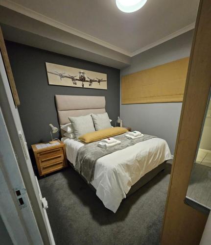 a bedroom with a bed and a table with a night stand at At Leisure Apartment 2 in Stellenbosch