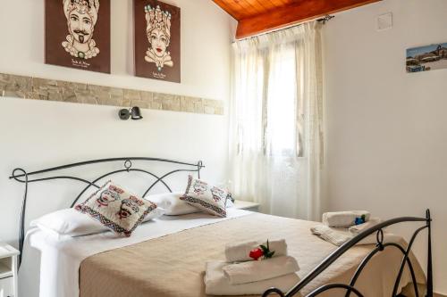 ein Schlafzimmer mit einem Bett und einem Fenster in der Unterkunft Casuzze I Mori Museum Alloggi di Charme tra Mare Natura e Tradizione Siciliana in Marzamemi