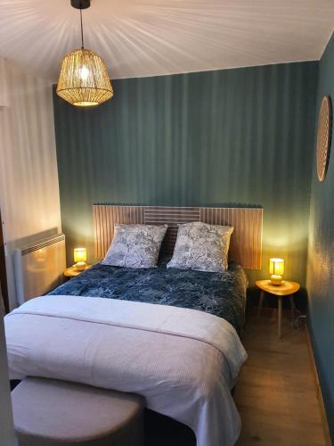 een slaapkamer met een bed met twee tafels en twee lampen bij Au Doubs lac in Malbuisson