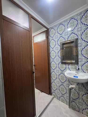a bathroom with a toilet and a sink and a door at Riad al anwar in Rabat