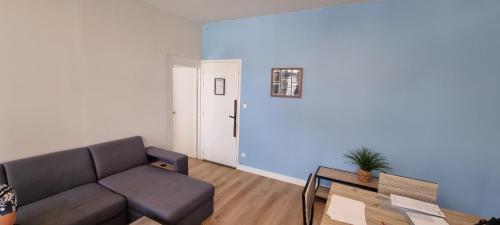 una sala de estar con un sofá y una mesa en Appartement proche Grand Parc 1 Chambre, en Mauléon