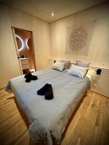 a bedroom with a large bed with two black shoes on it at N&L Signature - Ô Lodge in Mornas