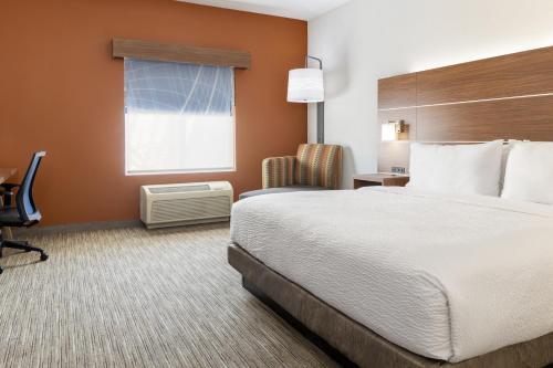 a hotel room with a bed and a desk and a window at Holiday Inn Express & Suites Las Vegas SW Springvalley by IHG in Las Vegas