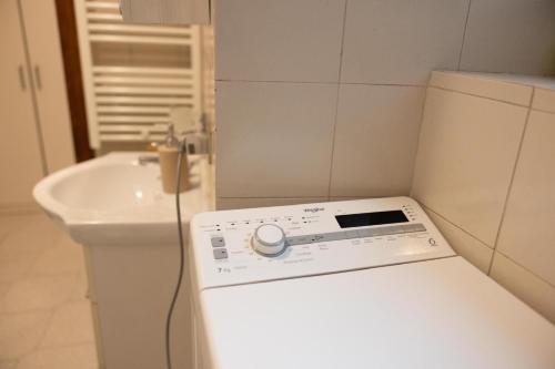 La Piccola Corte nel cuore di Como AC e wifi في كومو: مطبخ مع مغسلة وثلاجة بيضاء