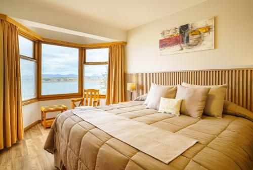 a bedroom with a large bed with a large window at Los Naranjos in Ushuaia