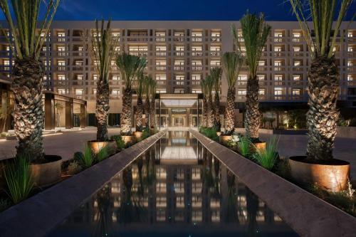 an exterior view of a hotel with palm trees and a pool at The Landmark Nicosia, Autograph Collection in Nicosia