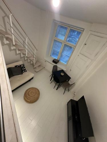 a room with a bed and a table and a television at Bright Loft Apartment Steps From Linnanmäki & Alppipuisto in Helsinki