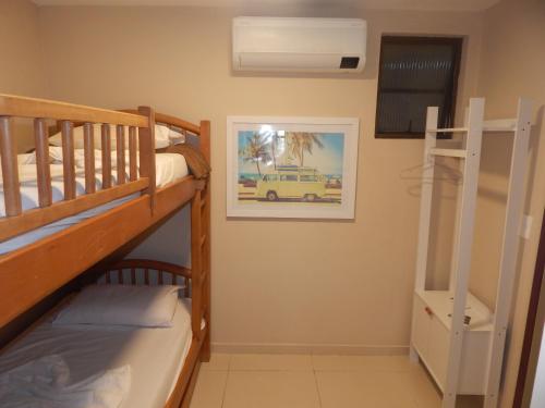 a bunk room with two bunk beds and a ladder at Apartamento Cabo Frio 3Q in Cabo Frio