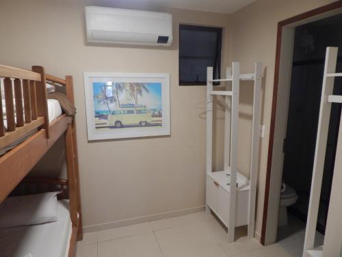 a bedroom with a bunk bed and a picture of a van on the wall at Apartamento Cabo Frio 3Q in Cabo Frio