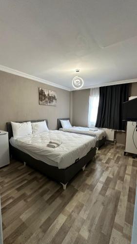 a bedroom with two beds and a television in it at Gürleyen Butik Otel in Küçük Çığlı