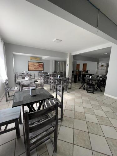 jadalnia ze stołami i krzesłami w pokoju w obiekcie Sunset Inn w mieście Florianópolis
