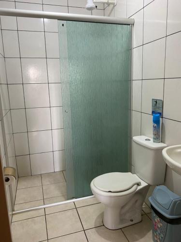 een badkamer met een toilet en een glazen douchedeur bij Chácara Santa Edwiges in Campinas