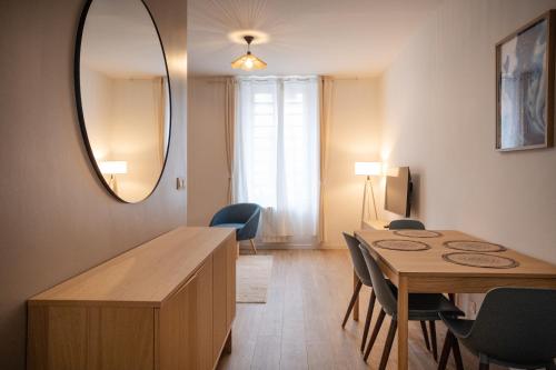 a dining room with a table and a mirror at Saint-Fons centre appartement meublé in Saint-Fons