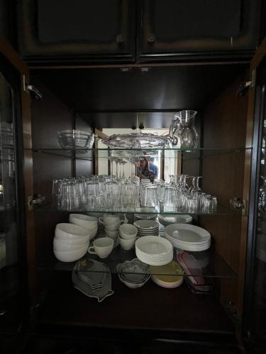 a shelf with plates and bowls and glasses on it at Яблунева садиба in Demidovka