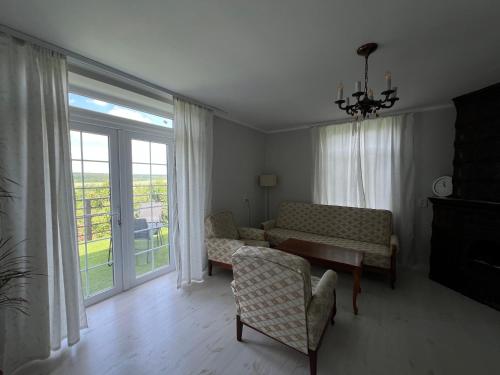 een woonkamer met een bank en stoelen en een raam bij Яблунева садиба 