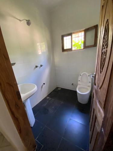 un bagno con un water bianco e un lavandino di Villa Soleil a Diani Beach