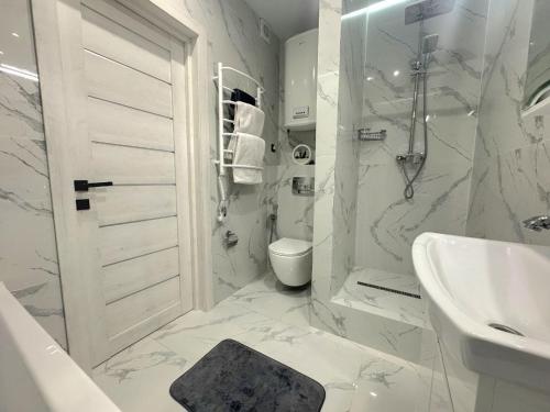 a white bathroom with a sink and a shower at Видові Апартаменти ЖК GREAT in Kyiv