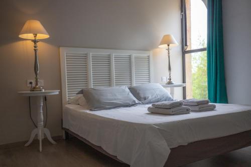 a bedroom with a bed with two towels on it at Le Mas d'Eymard in Arles