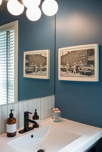 ein Badezimmer mit einem weißen Waschbecken und einem Spiegel in der Unterkunft Talbot Commons Hotel in Taylor