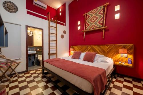 a bedroom with a large bed with red walls at Masaya Santa Marta in Santa Marta