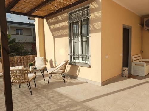 a patio with chairs and a table and a window at Terrazza Groane in Garbagnate Milanese