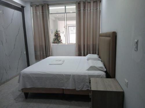 Un dormitorio con una cama con un árbol de Navidad dentro. en Amaru Lodge, en Tingo María