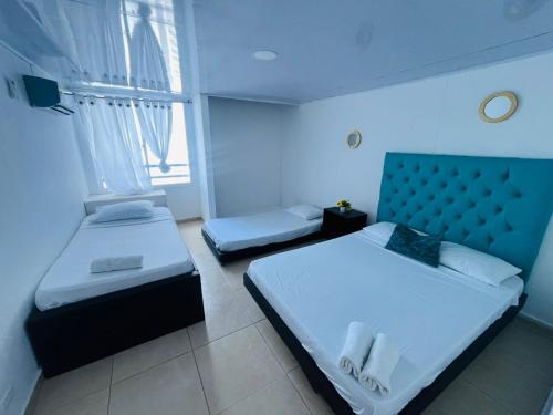 a hotel room with two beds and a window at Vacaciones en el Caribe - Laguito Cartagena al lado de bocagrande in Cartagena de Indias