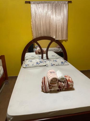 a bed with two blankets and pillows on it at Chácara São Marcos in Ibiúna