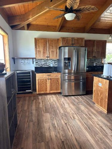 a kitchen with a stainless steel refrigerator and wooden cabinets at The Gray House