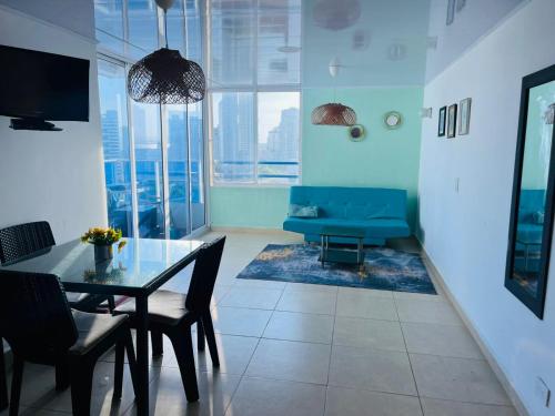 a dining room with a table and a blue couch at Vacaciones en el Caribe - Laguito Cartagena al lado de bocagrande in Cartagena de Indias