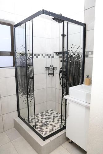 a shower stall in a bathroom with a sink at Lethabo Guesthouse in Ga-Mankopane