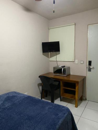 a bedroom with a desk with a computer and a television at Habitacion C10 privada centro monterrey in Monterrey