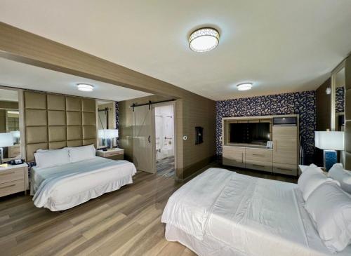 Una habitación grande con dos camas y un televisor en 3 Palms Tucson North Foothills, en Tucson