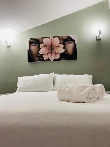 a bedroom with a white bed with two pictures on the wall at PsApart in Augusta