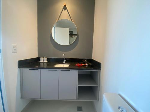 a bathroom with a sink and a mirror at Apt completo: ar cond piscina e academia no Centro in Taubaté