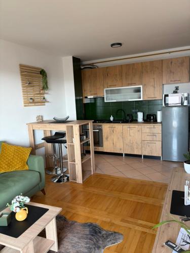 a kitchen and living room with a green couch at Apartman *Joy* in Osijek